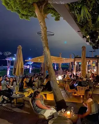a group of people sitting on a patio at night at My House of Inspiration in Athens by the sea in Athens