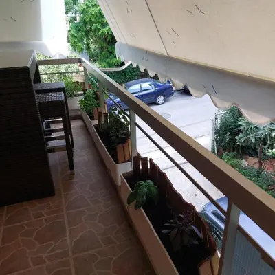 a balcony with potted plants and a car on a street at My House of Inspiration in Athens by the sea in Athens