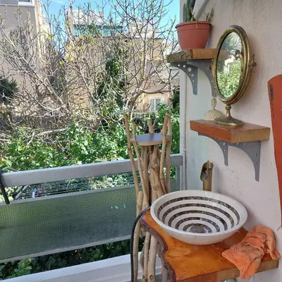 a mirror sitting on a chair next to a window at My House of Inspiration in Athens by the sea in Athens