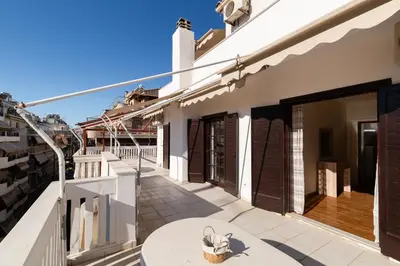 a balcony of a house with a table at Seaside Dublex with 2 Large Terraces Walk to the Beach in Piraeus