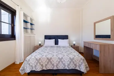 a bedroom with a bed and a desk and a window at Seaside Dublex with 2 Large Terraces Walk to the Beach in Piraeus