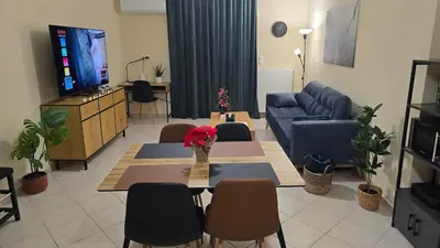 a living room with a couch and a table and chairs at Piraeus Gate - PS5 in Piraeus