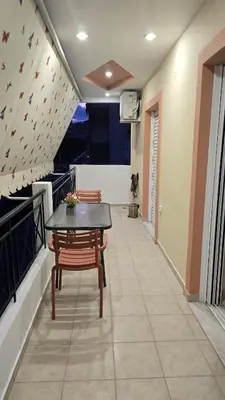 a balcony with a table and chairs in a room at Piraeus Gate - PS5 in Piraeus