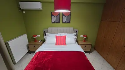 a bedroom with a bed with a red blanket on it at Piraeus Gate - PS5 in Piraeus