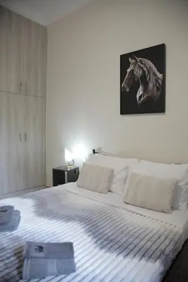 a bedroom with a bed with a horse picture on the wall at Casa Urbana in Athens