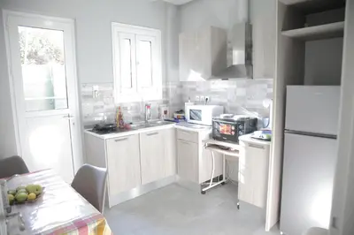 a kitchen with white cabinets and a white refrigerator at Casa Urbana in Athens