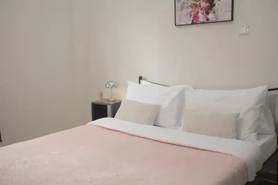 a bedroom with a white bed with white pillows at Casa Urbana in Athens