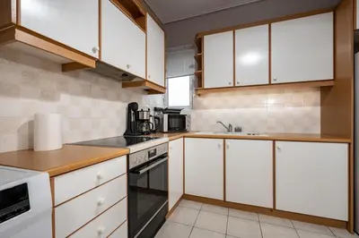 a kitchen with white cabinets and white appliances at Family 2BRM Flat in Patissia-Acropolis View by ΜΡS in Athens
