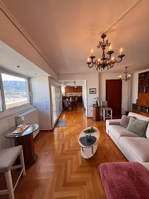 a living room with a couch and a chandelier at Athens Sky Penthouse in Athens