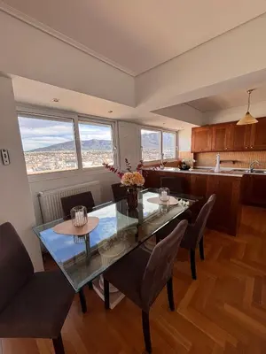 a kitchen and dining room with a glass table and chairs at Athens Sky Penthouse in Athens
