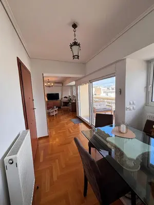 a dining room with a glass table and a living room at Athens Sky Penthouse in Athens