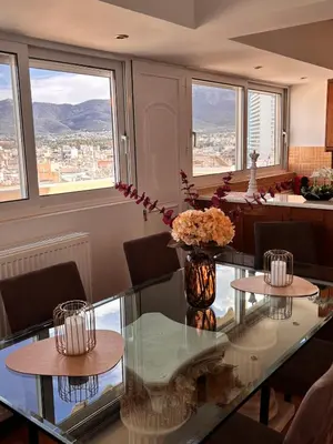 a dining room with a glass table with flowers on it at Athens Sky Penthouse in Athens