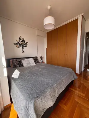 a bedroom with a large bed with a gray comforter at Athens Sky Penthouse in Athens