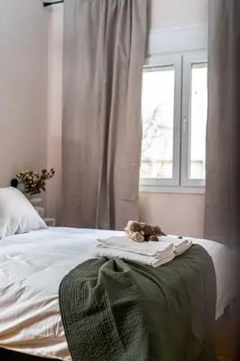 a teddy bear sitting on a blanket on a bed at Elegant City Retreat with Two Balconies in Athens