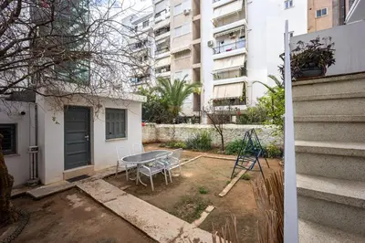 a patio with a table and chairs in front of a building at Elegant City Retreat with Two Balconies in Athens