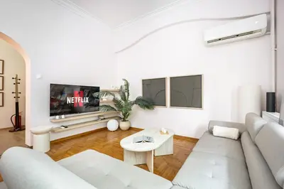 a white living room with a couch and a tv at Elegant City Retreat with Two Balconies in Athens