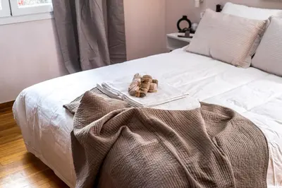 a bed with a blanket and two towels on it at Elegant City Retreat with Two Balconies in Athens