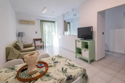 a living room with a table and a tv at Seaside Home in Porto Rafti