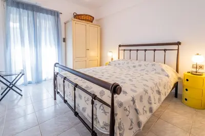 a bedroom with a bed and a yellow dresser at Seaside Home in Porto Rafti