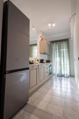 a kitchen with a stainless steel refrigerator and white cabinets at Seaside Home in Porto Rafti