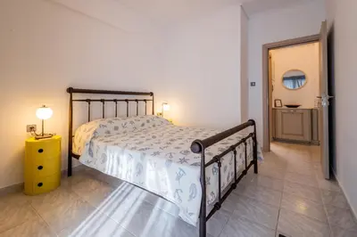 a bedroom with a large bed and a yellow night stand at Seaside Home in Porto Rafti