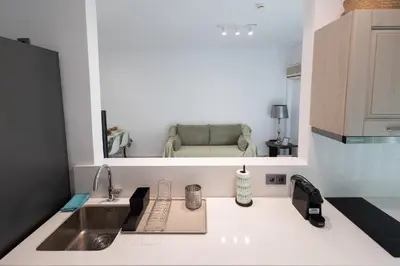 a kitchen with a sink and a chair in a mirror at Seaside Home in Porto Rafti
