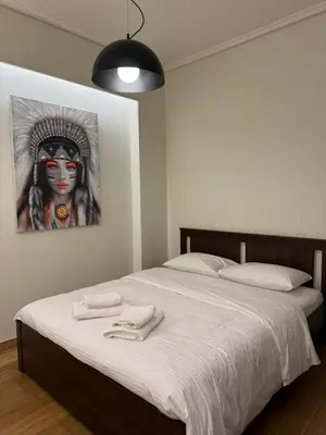 a bedroom with a bed with a painting on the wall at Urban Muse VI - Archaeological Museum of Athens in Athens