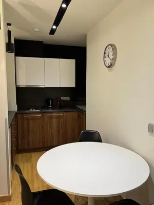 a white table with chairs and a clock on a wall at Urban Muse VI - Archaeological Museum of Athens in Athens
