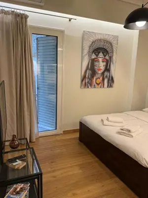 a room with a bed and a painting of a woman at Urban Muse VI - Archaeological Museum of Athens in Athens