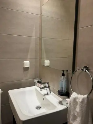 a bathroom with a white sink and a mirror at Urban Muse VI - Archaeological Museum of Athens in Athens