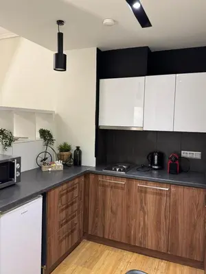 a kitchen with white cabinets and black counter tops at Urban Muse VI - Archaeological Museum of Athens in Athens