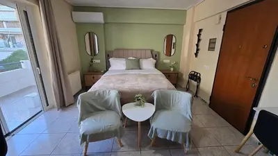a bedroom with a bed with two chairs and a table at Space One in Piraeus