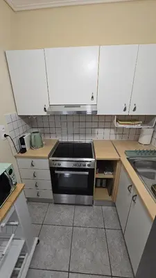 a kitchen with white cabinets and a stove top oven at Space One in Piraeus