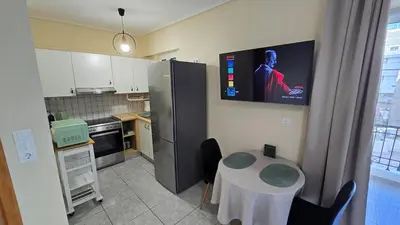 a kitchen with a table and a tv on the wall at Space One in Piraeus
