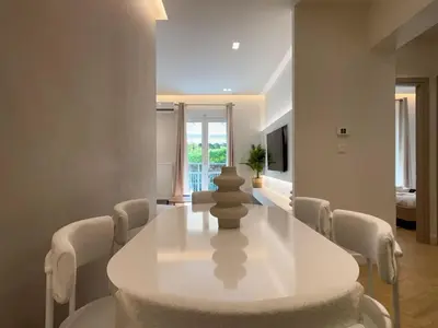 a white dining room with a white table and chairs at Elegant Living in Glyfada Center in Athens