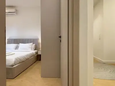 a bedroom with a bed and a door to a room at Elegant Living in Glyfada Center in Athens