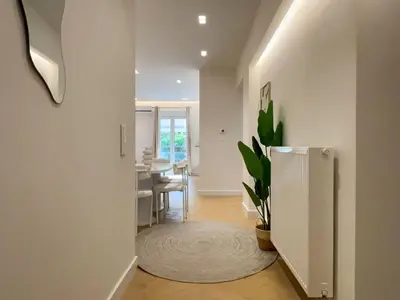 a white hallway with a dining room and a table at Elegant Living in Glyfada Center in Athens
