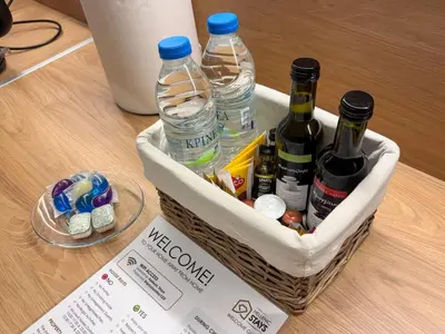a basket with bottles of wine and water on a table at Elegant Living in Glyfada Center in Athens