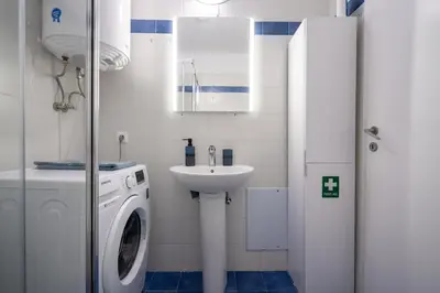 a bathroom with a washing machine and a sink at Downtown Family Apartment - Walk to Metro by ΜΡS in Athens