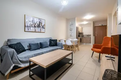 a living room with a blue couch and a table at Downtown Family Apartment - Walk to Metro by ΜΡS in Athens