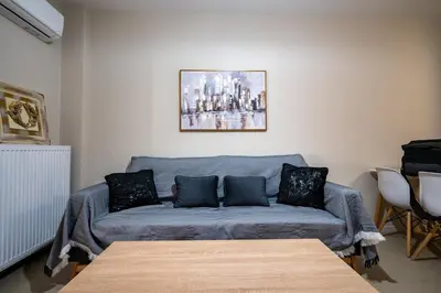 a living room with a blue couch with pillows at Downtown Family Apartment - Walk to Metro by ΜΡS in Athens