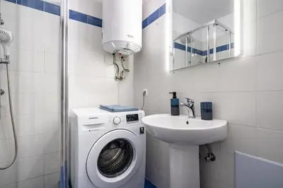 a bathroom with a washing machine and a sink at Downtown Family Apartment - Walk to Metro by ΜΡS in Athens