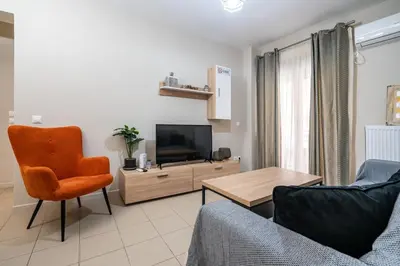 a living room with a couch and a television at Downtown Family Apartment - Walk to Metro by ΜΡS in Athens