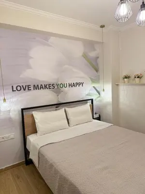 a bedroom with a bed with a sign that reads love makes you happy at Paula Acropolis Thissio in Athens