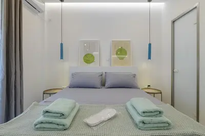 a bedroom with a bed with two towels on it at NEW Dodekanisou 53 Glifada in Athens