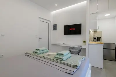 a white kitchen with towels on a bed at NEW Dodekanisou 53 Glifada in Athens
