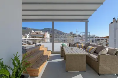 a patio with a couch and a table on a balcony at NEW Dodekanisou 53 Glifada in Athens