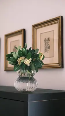 a glass vase with flowers in it on a table at Bamboo & Bird House, Chalandri in Athens