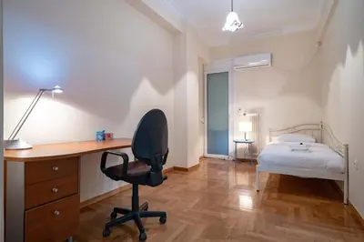 a bedroom with a desk and a bed and a chair at Blue Harmony 3BR - Heart of Athens by ΜΡS in Athens