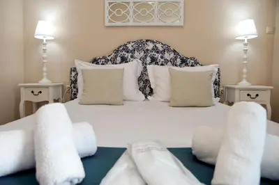 a bedroom with a white bed with pillows at Best House Kalipso Neo Faliro Piraeus in Piraeus